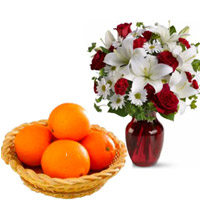 Send Online Rakhi of 2 White Lily 6 White Gerbera and 6 Red Roses Vase with 12 pcs Fresh Orange Basket